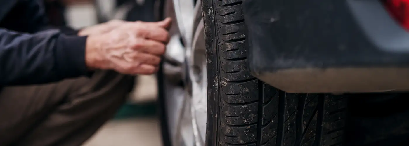 man checking condition of his car tyres